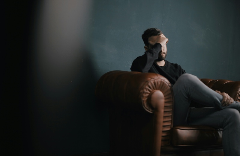 Man sitting on a leather couch having a panic attack